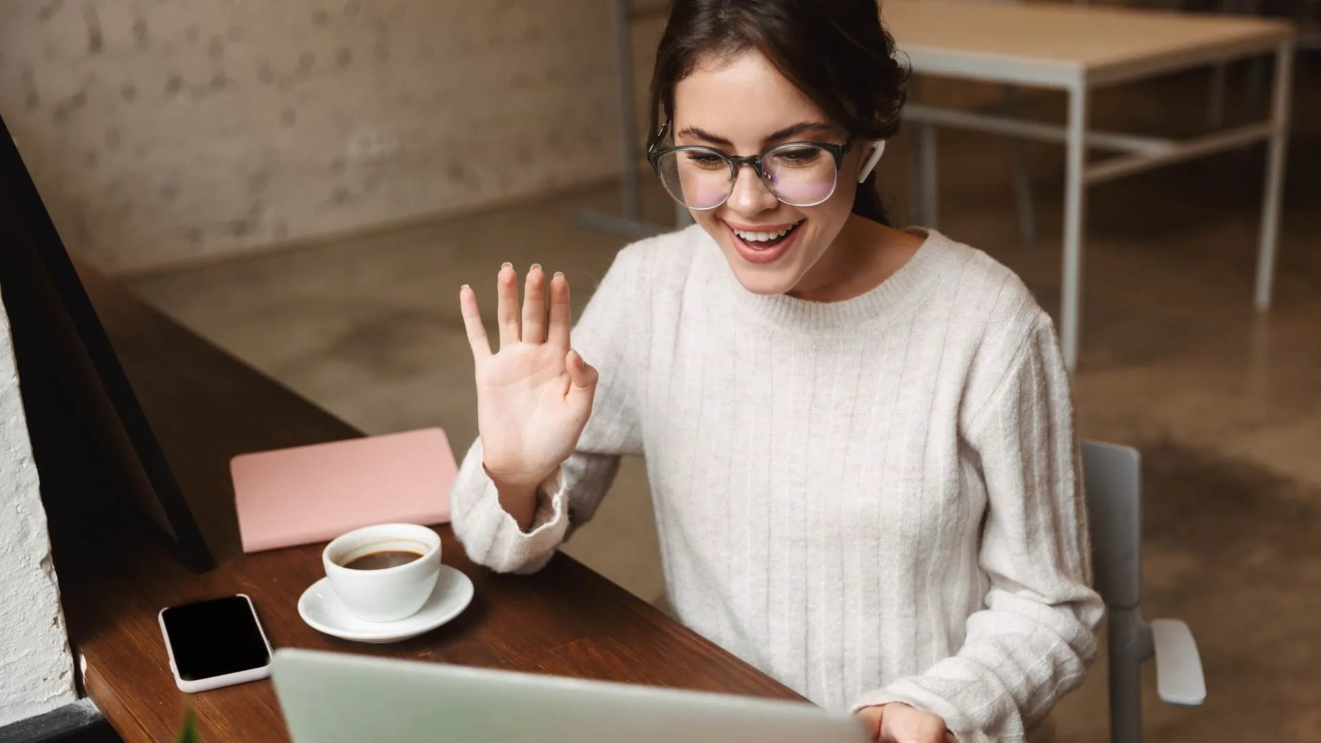 woman waving at computer video production service