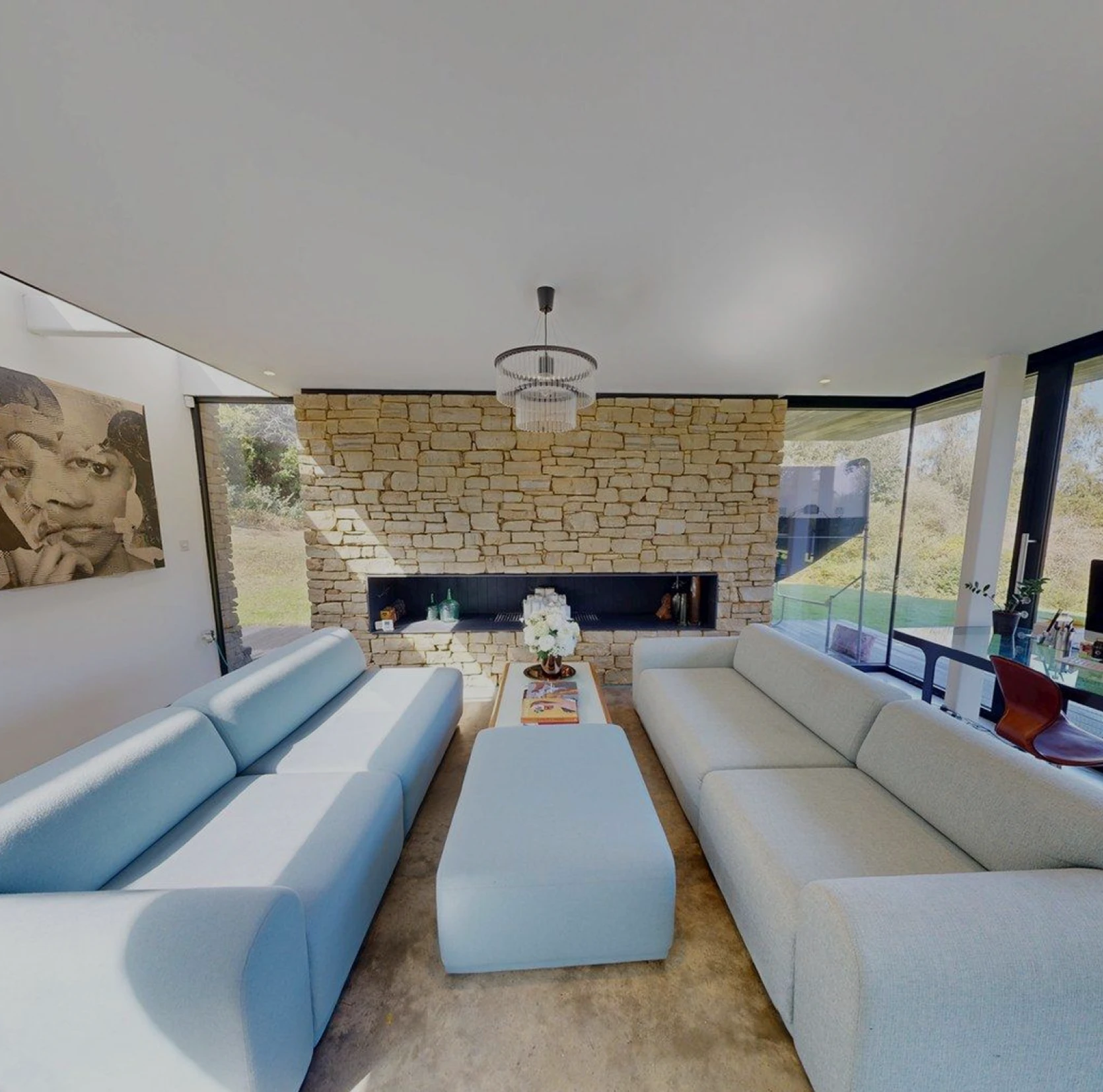 A high-contrast architectural shot of a modern living space centered on a stone feature wall.