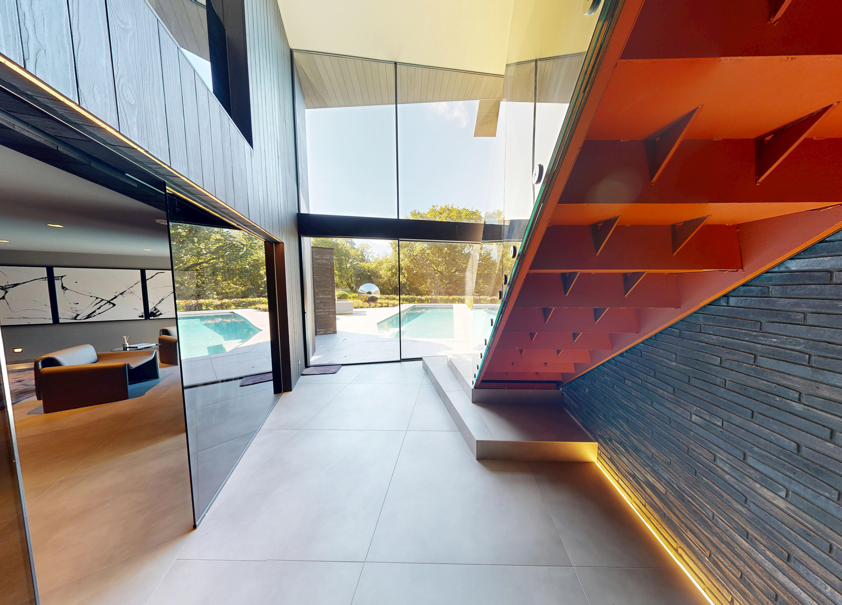 A minimalist interior view of a hallway leading into a kitchen area.