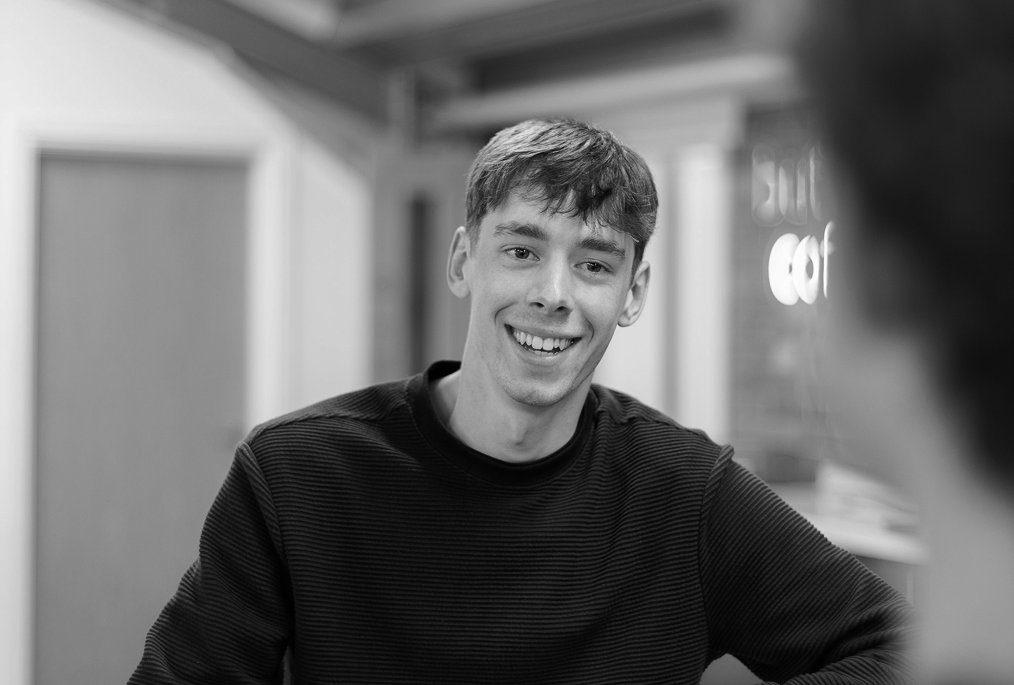Close-up interior shot of a living room featuring modern wooden chairs and cabinetry.