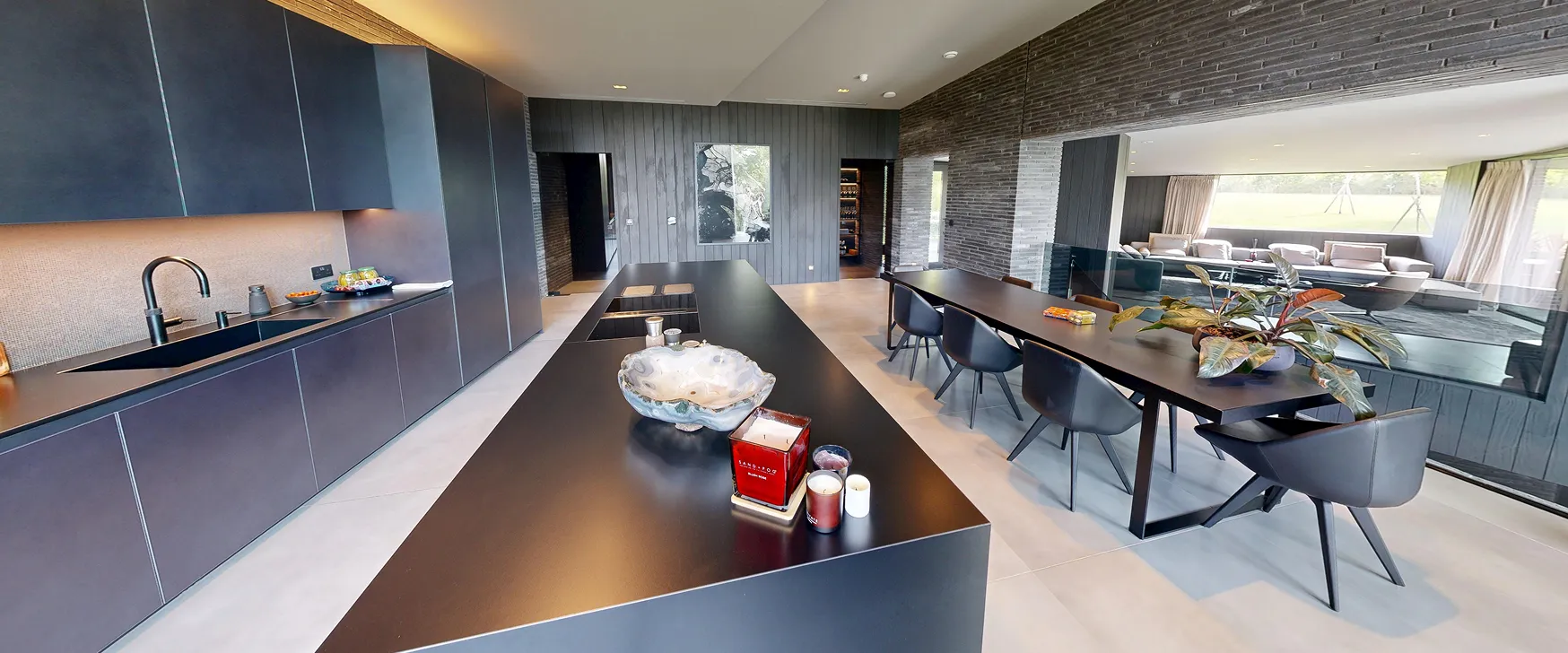 Grayscale photograph of a modern wooden walkway over water with dramatic sunlight shadows.