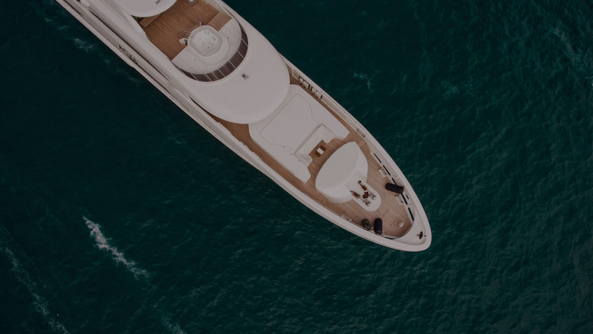 Aerial view of a luxury yacht deck on dark water
