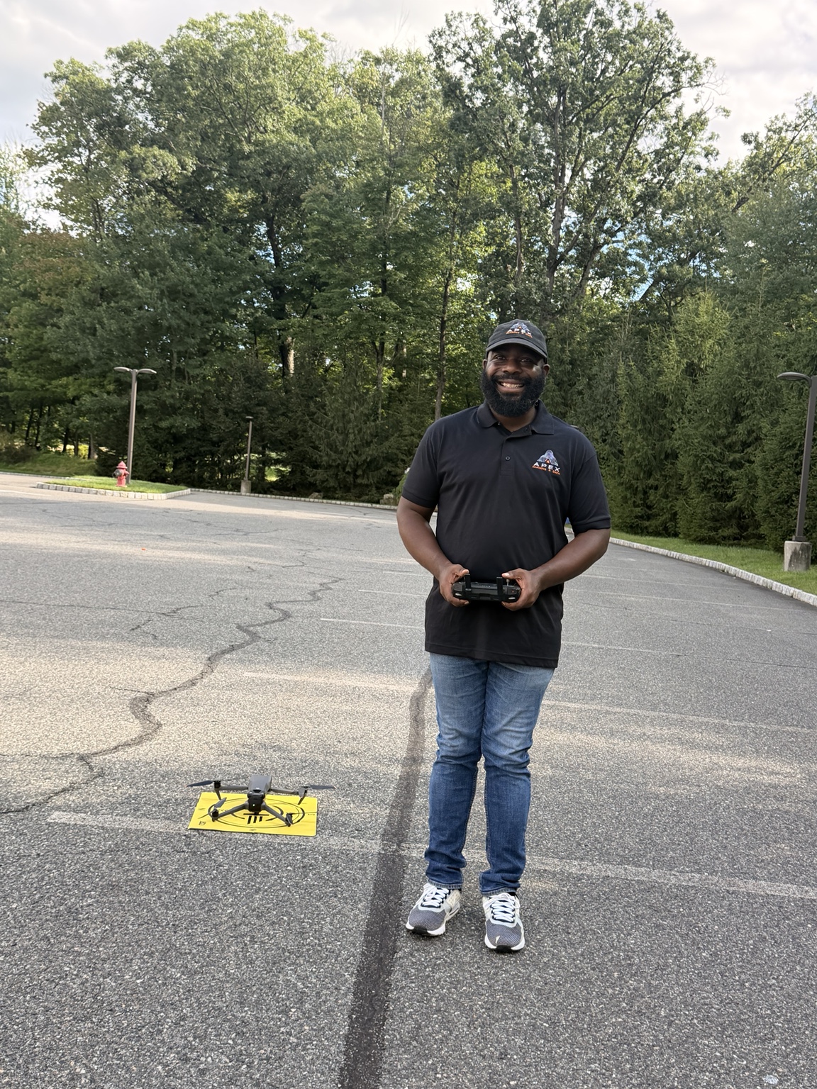 Jay Tucker, founder of Apex Imaging and Data Solutions, holding a drone controller beside an Apex landing pad