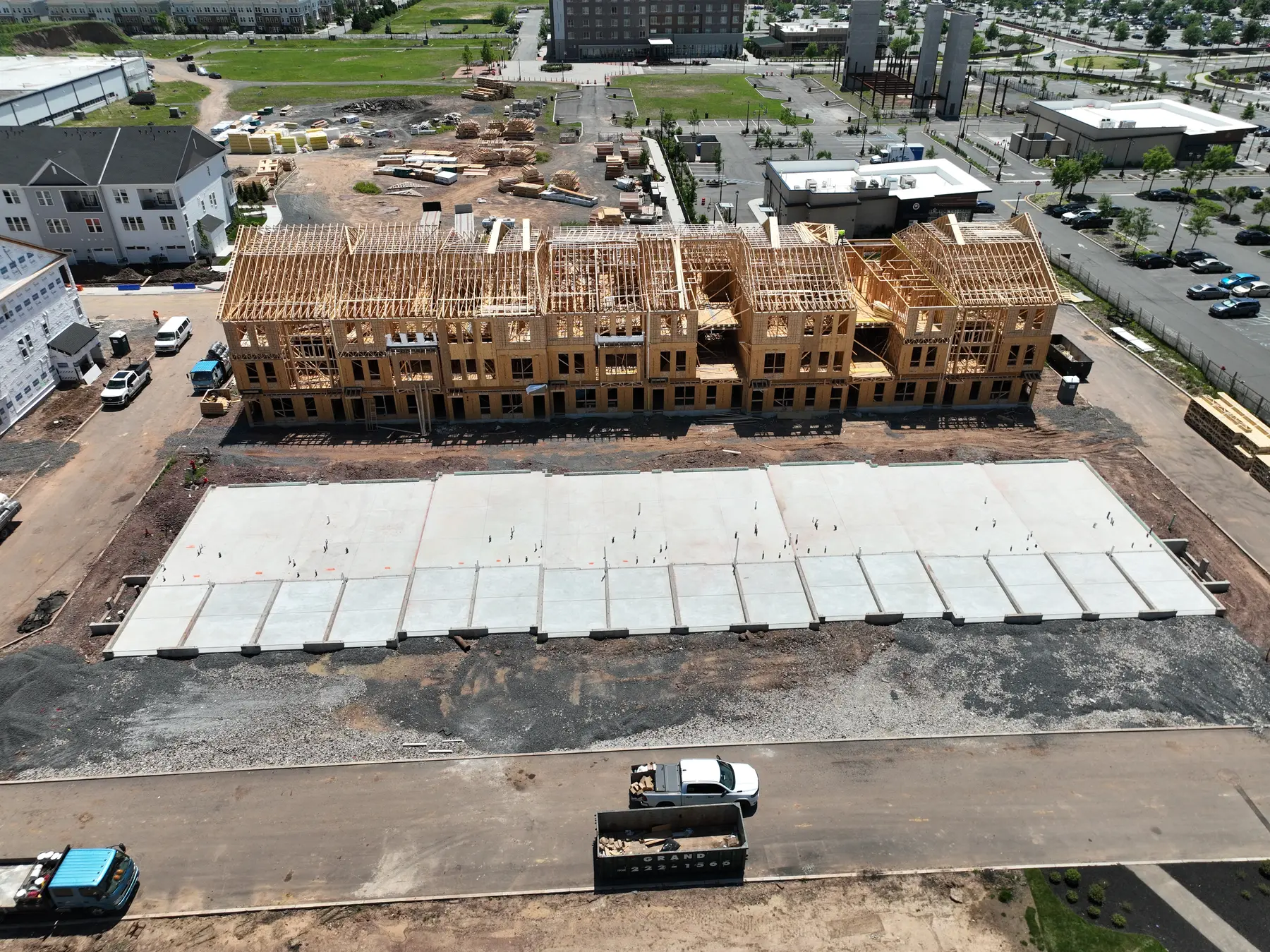 Oblique aerial view documenting structural wood framing across an active multi-building construction site
