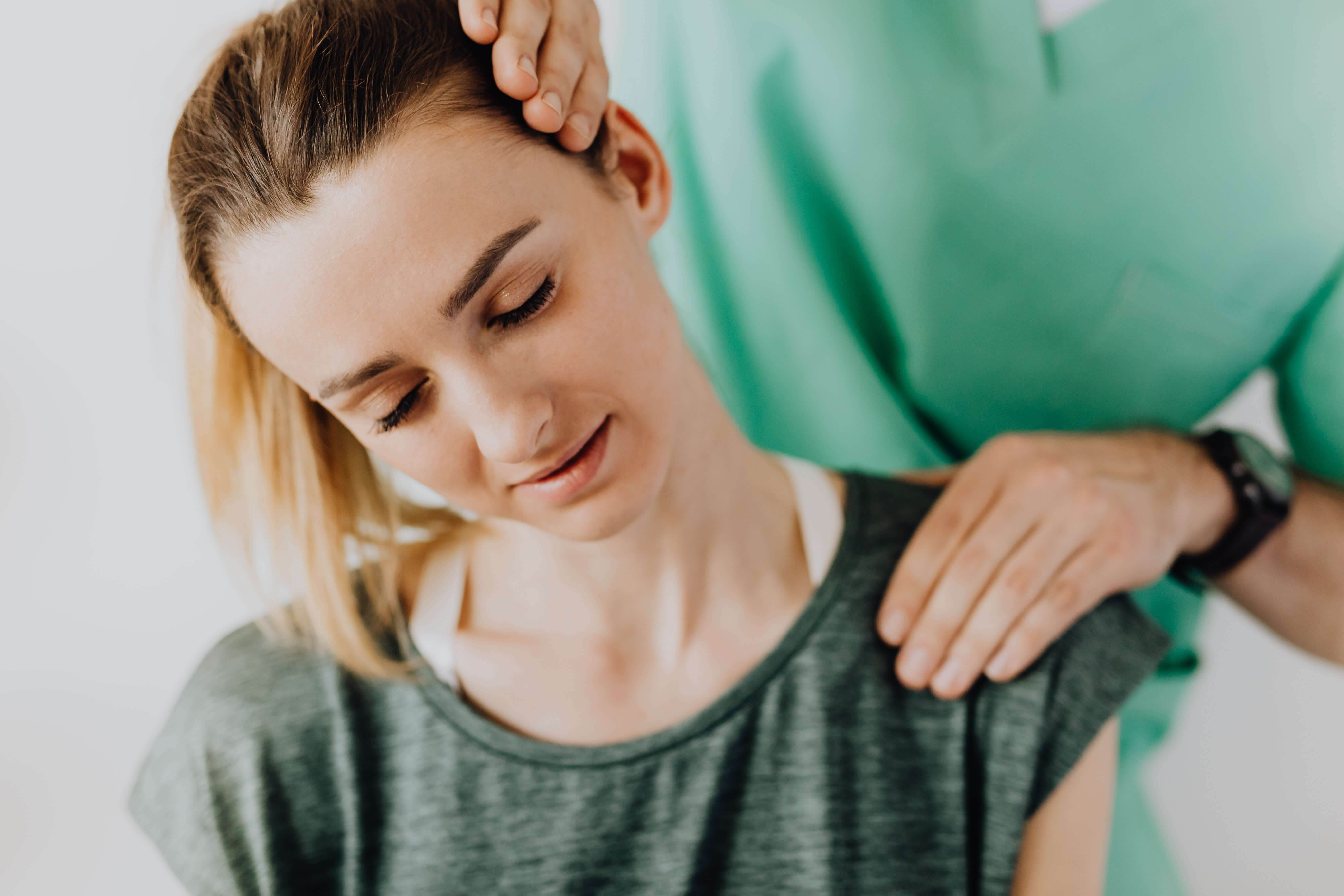 Woman with neck pain receiving an exam