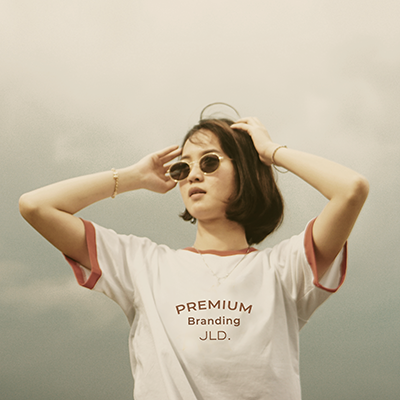 A woman wearing a burnt orange sweatshirt with the words 'Premium Branding' and the JLD logo 