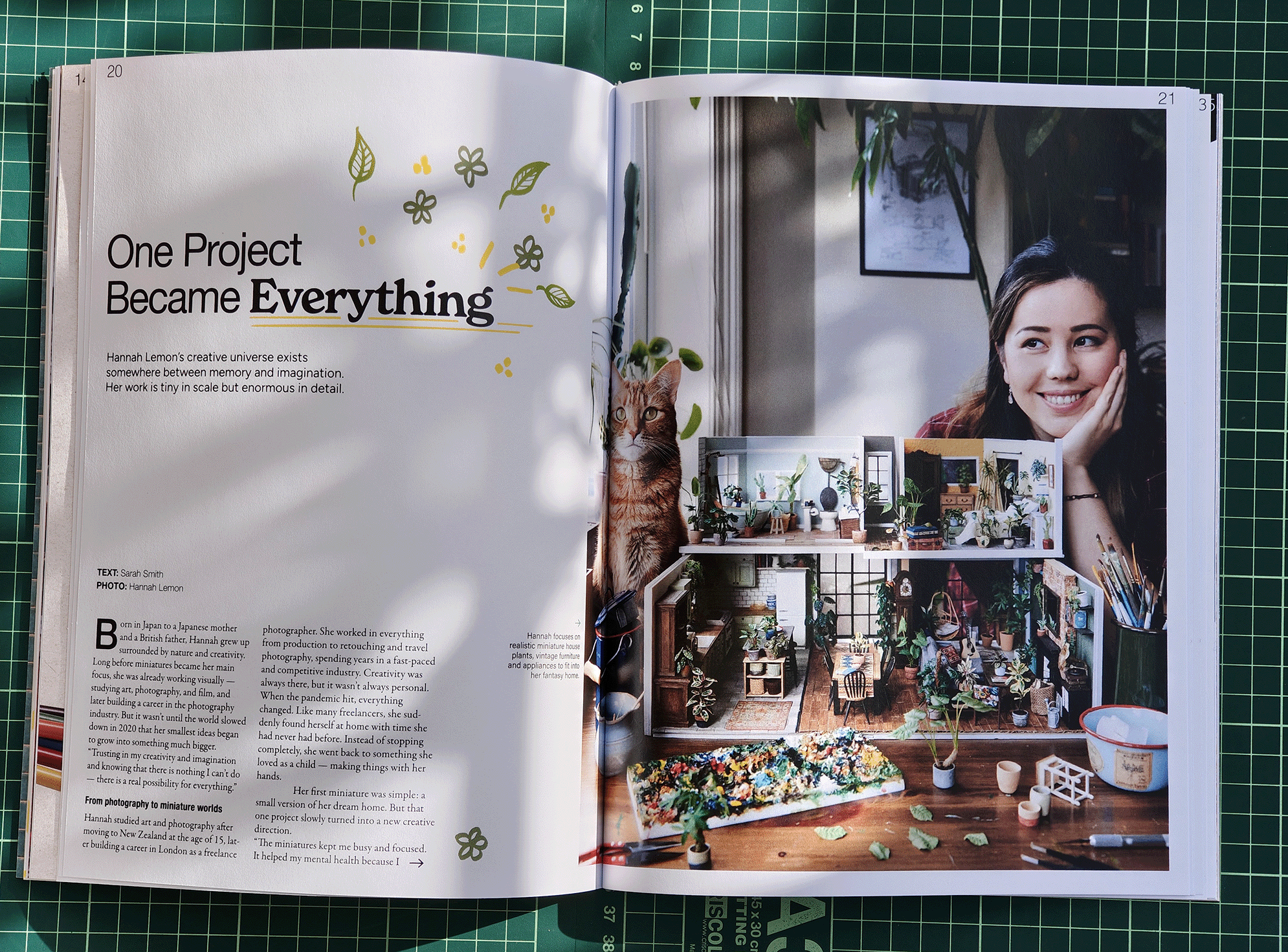 Magazine spread featuring Hannah Lemon with a cat, miniature house models, and art supplies on a table.