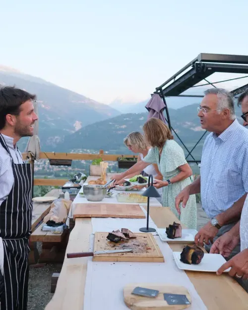 Serving guests at a long table in the Alps