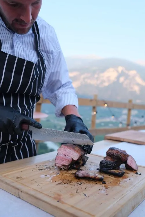 Slicing tira de asado, mountains behind