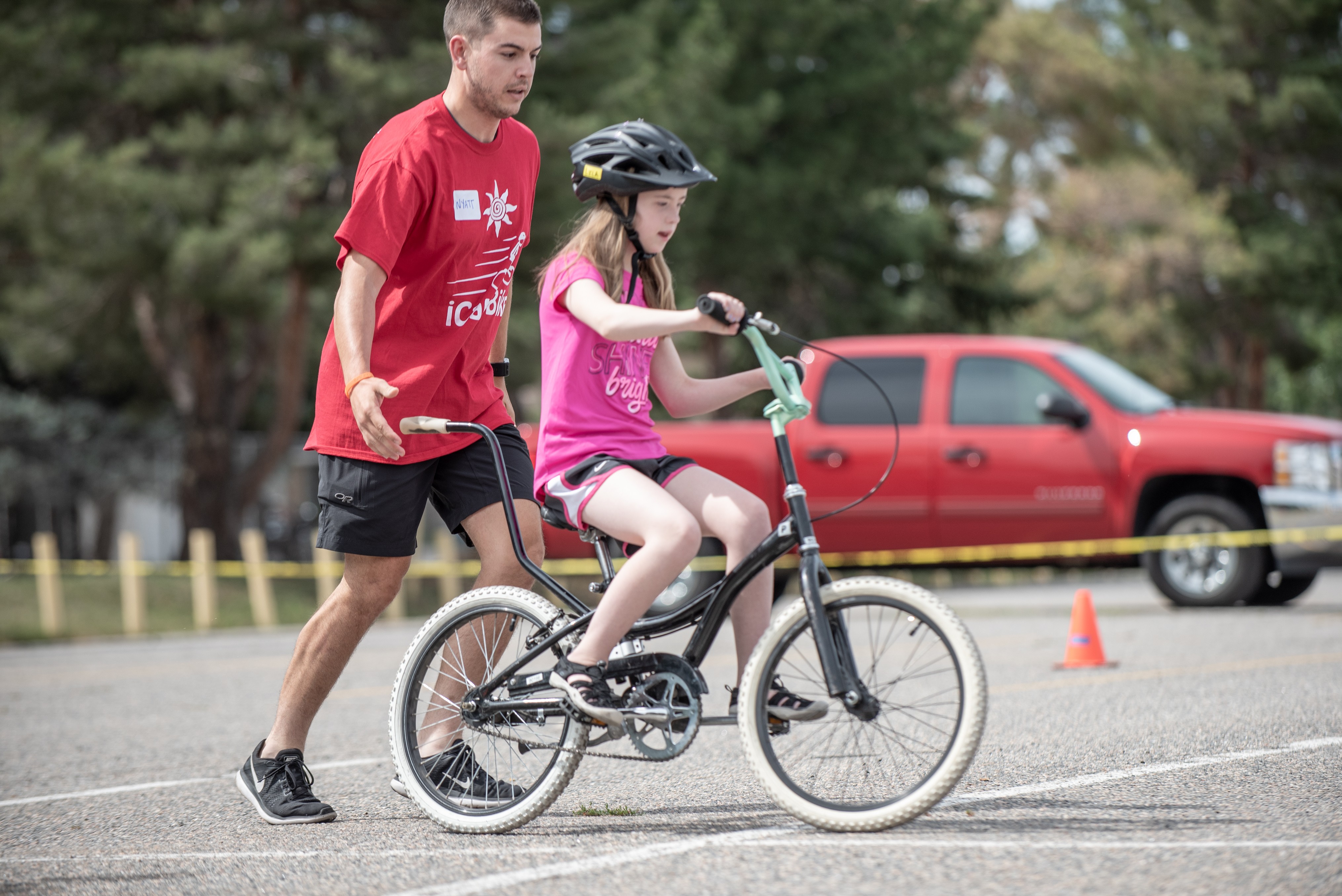 Certified instructor helping a girl with a disability learn to ride a bike at Cycle Movement's adaptive cycling camp in Colorado