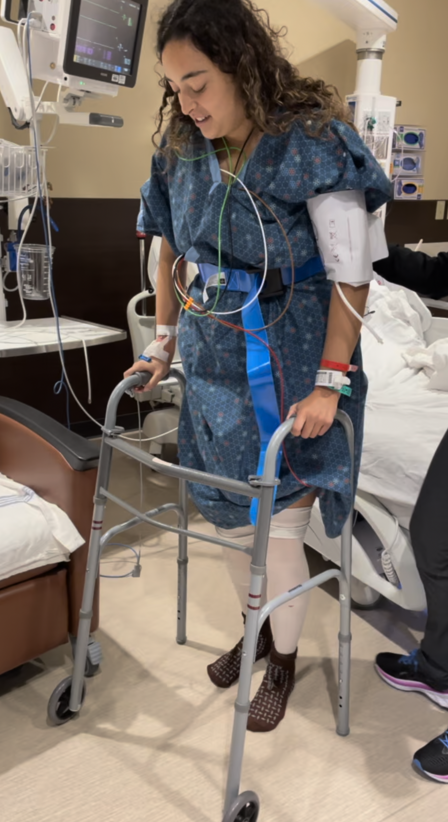 Ashlen using a walker in the hospital during recovery from back surgery