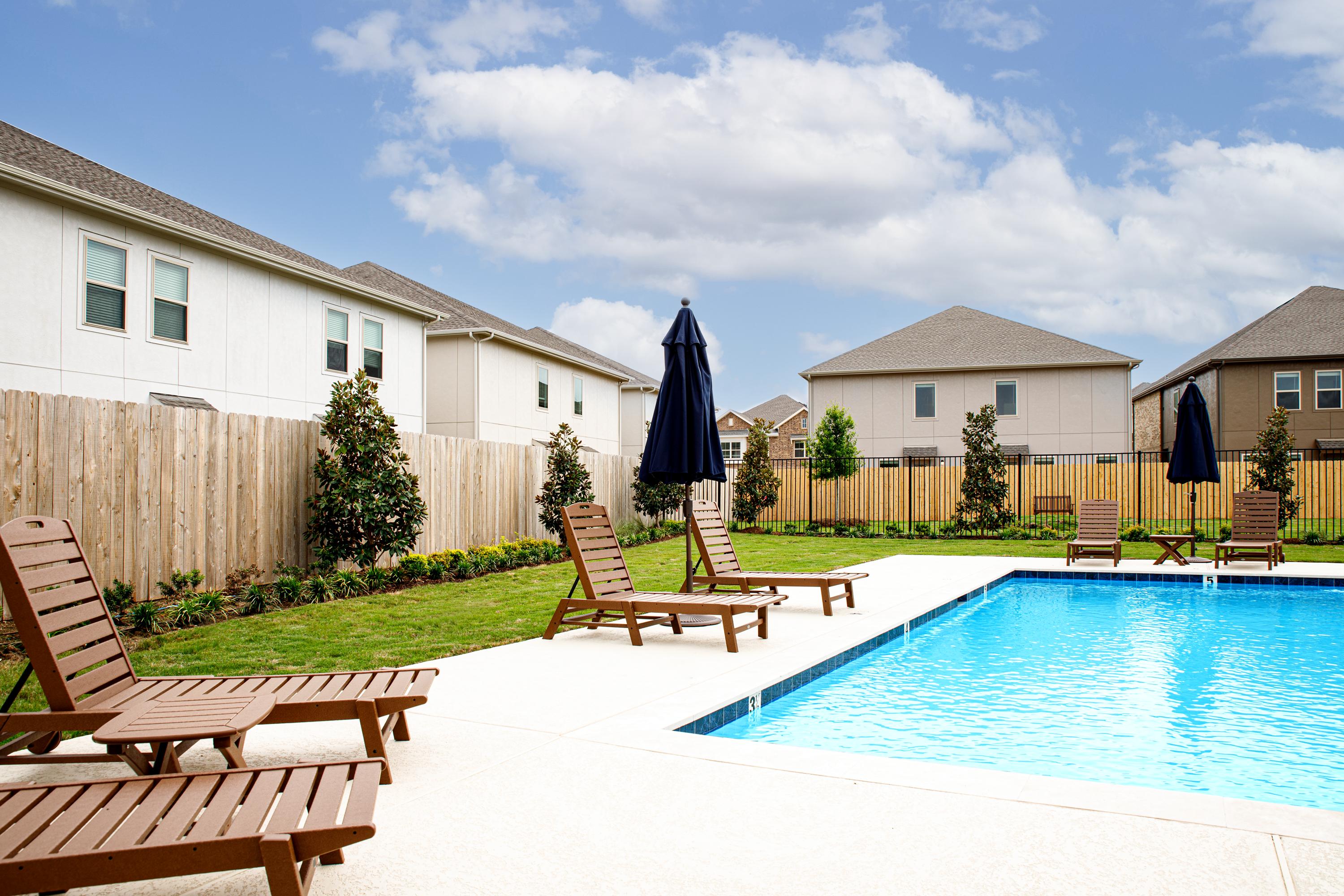 swimming pool with lounge chairs and umbrellas