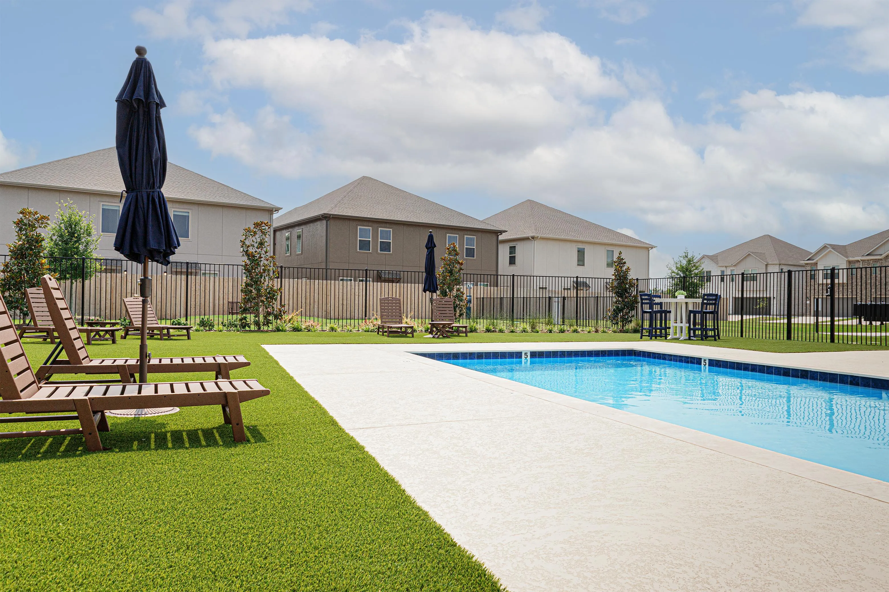 swimming pool with lounge chairs and umbrellas