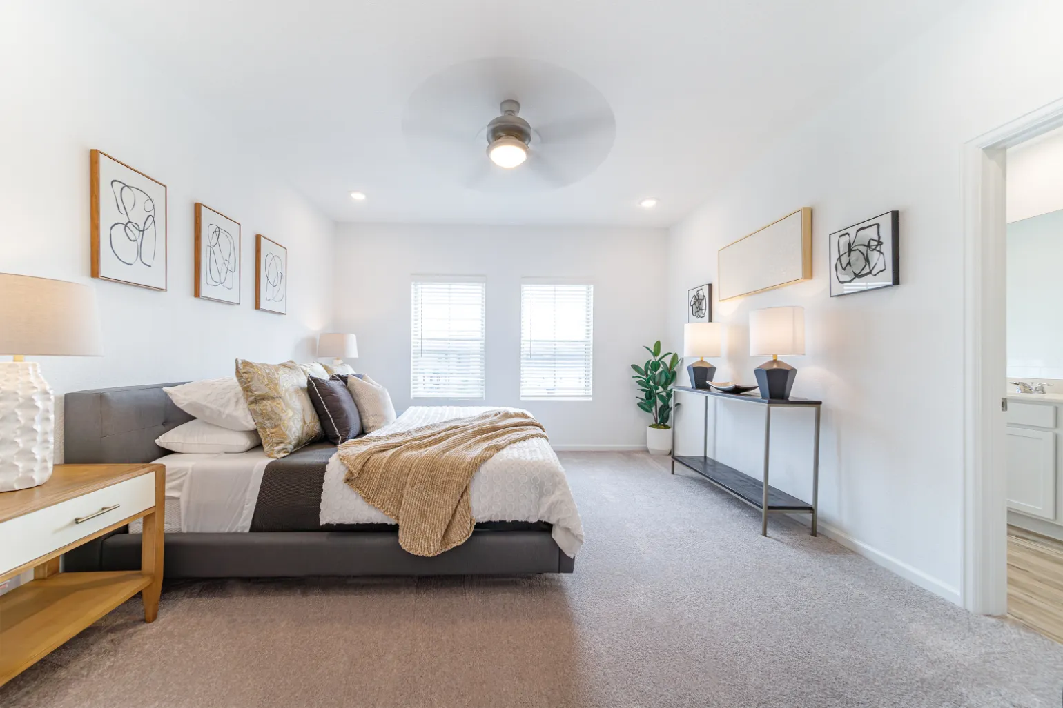 spacious bedroom with bed, ceiling fan, and large windows