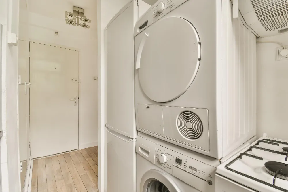 Stacked washer and dryer unit installed in compact laundry space