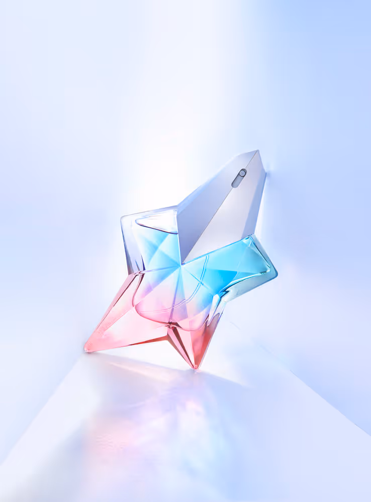 A perfume bottle in a star shape with reflections and colours