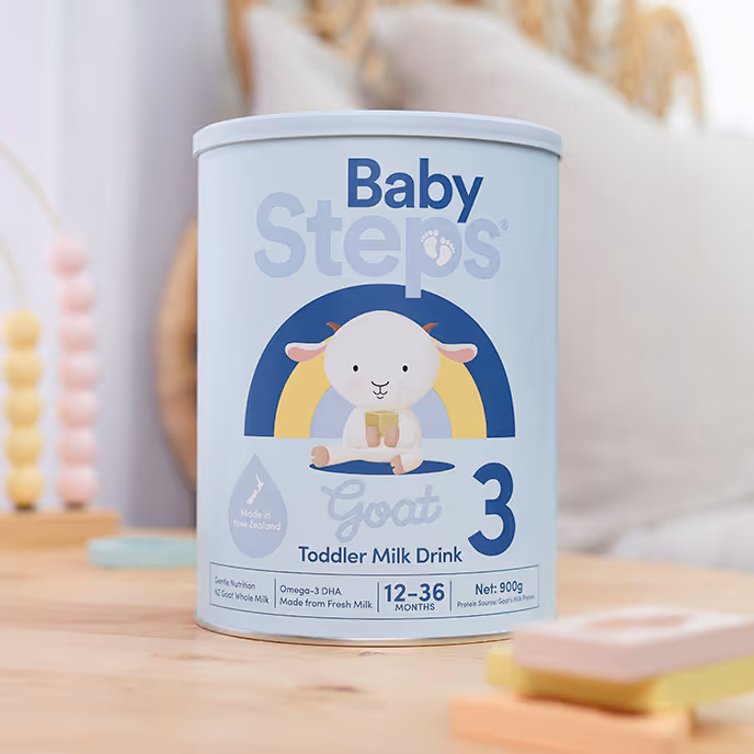 Container of Baby Steps Goat Toddler Milk Drink for 12-36 months with a cartoon goat and rainbow.