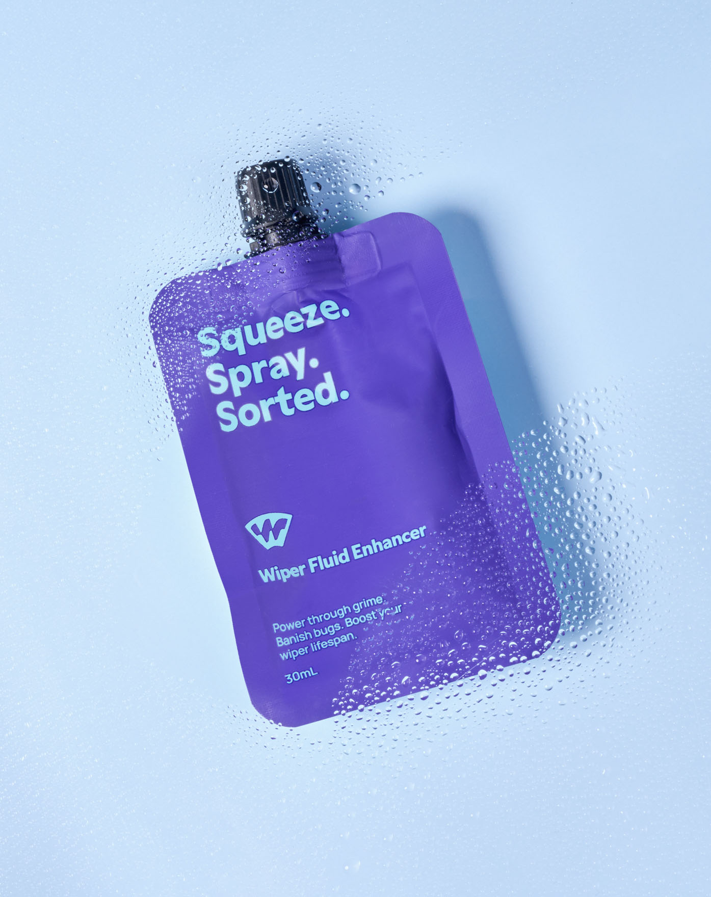 Auckland product photography of a Wiper Fluid Enhancer 30ml pouch photographed through a water-droplet covered surface, by Amanda Hughes Photography.