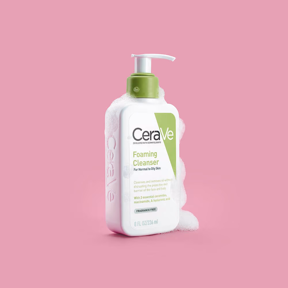 Auckland product photography of CeraVe Foaming Cleanser surrounded by soap foam, captured by Amanda Hughes Photography against a bold pink background.