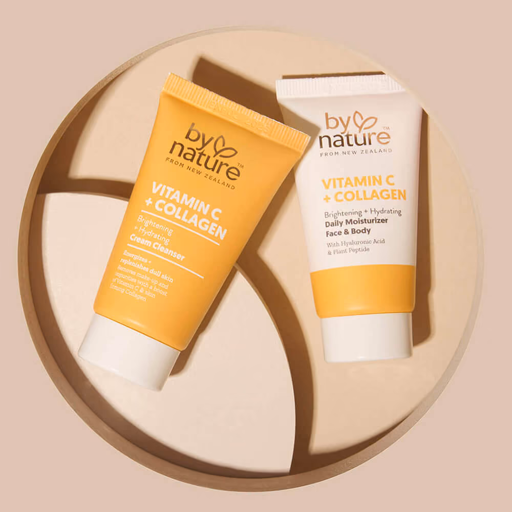Auckland product photography of By Nature Vitamin C + Collagen Cream Cleanser and Daily Moisturiser styled on a circular wooden tray with geometric shadow detail, by Amanda Hughes Photography.