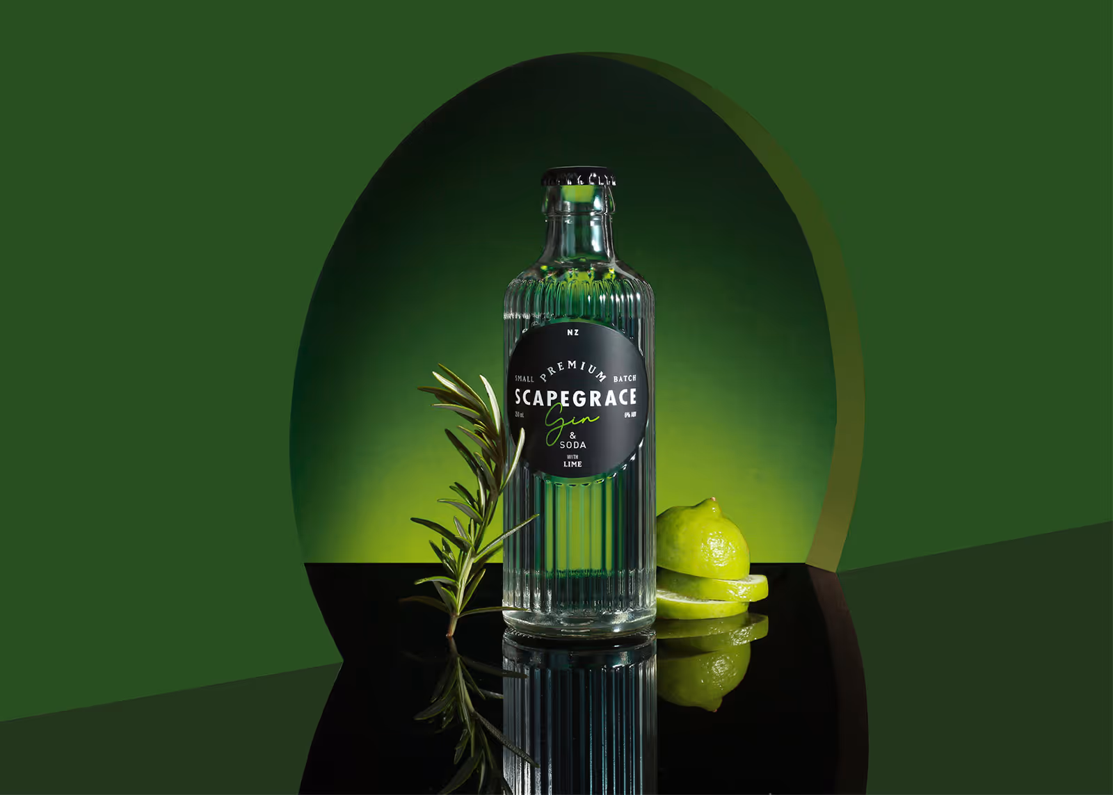 Scapegrace Gin & Soda bottle with lime slices and rosemary on reflective black surface and green background.