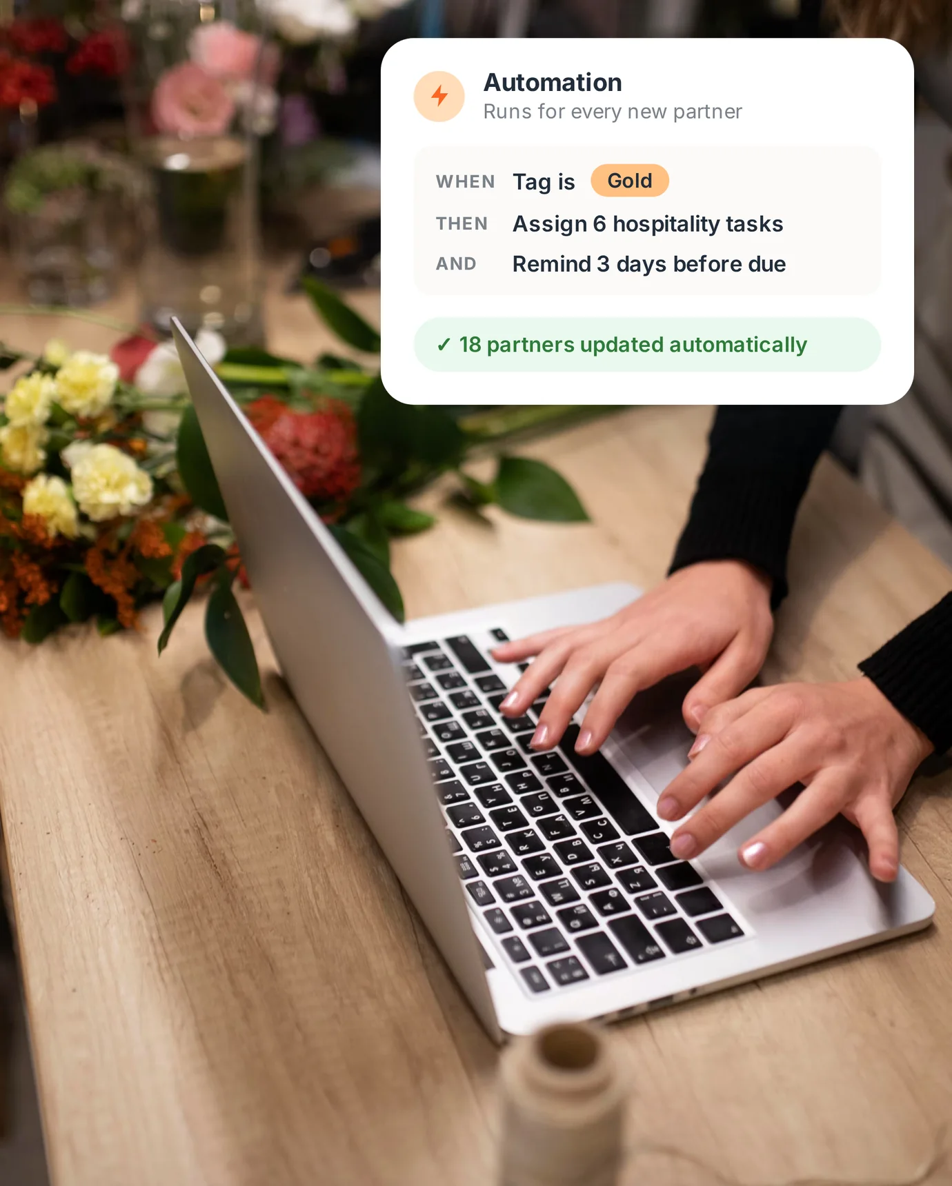 Florist typing on a laptop, with a PartnerHQ automation card: when a partner is tagged Gold, assign hospitality tasks and send reminders.