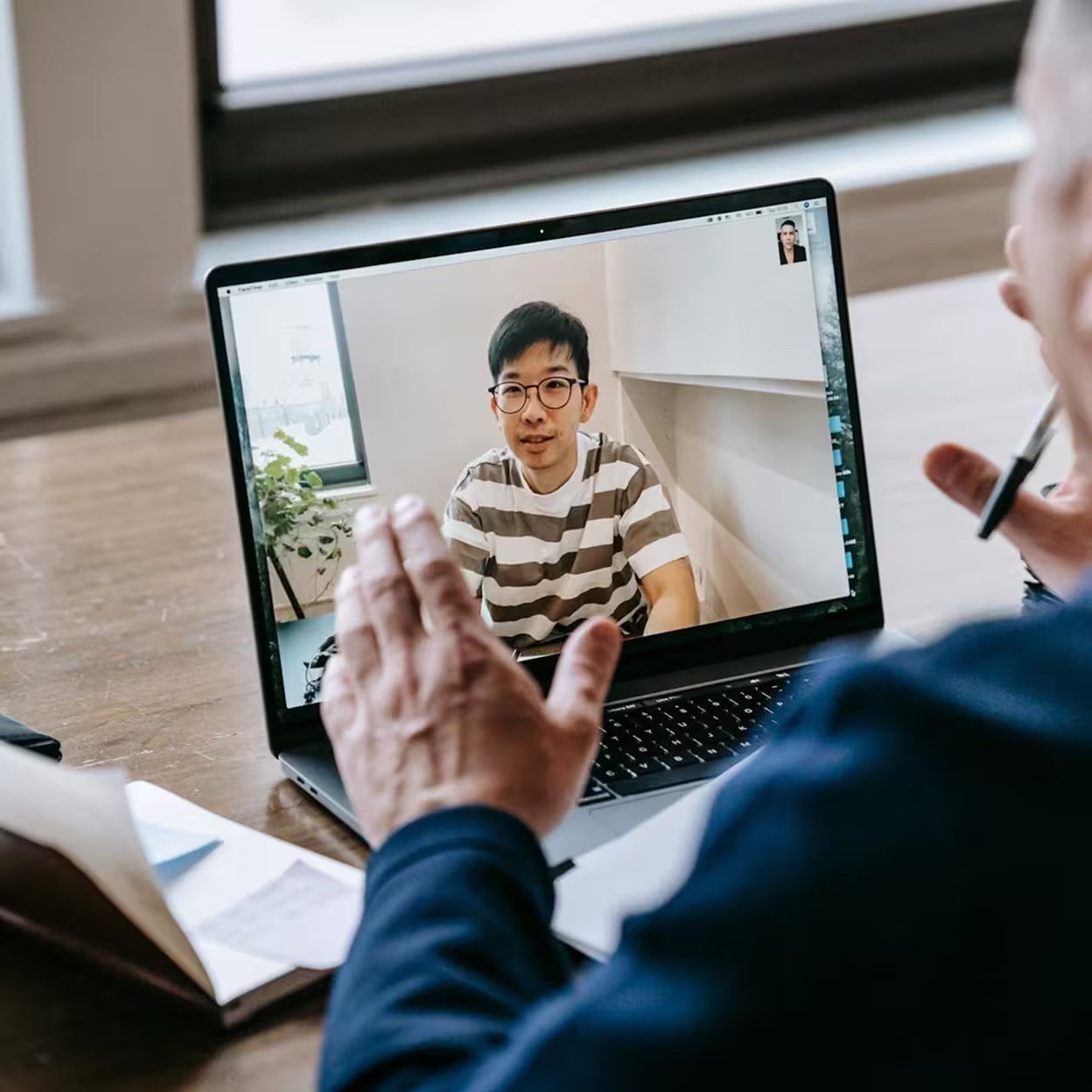 Online interview between two men, via a laptop.