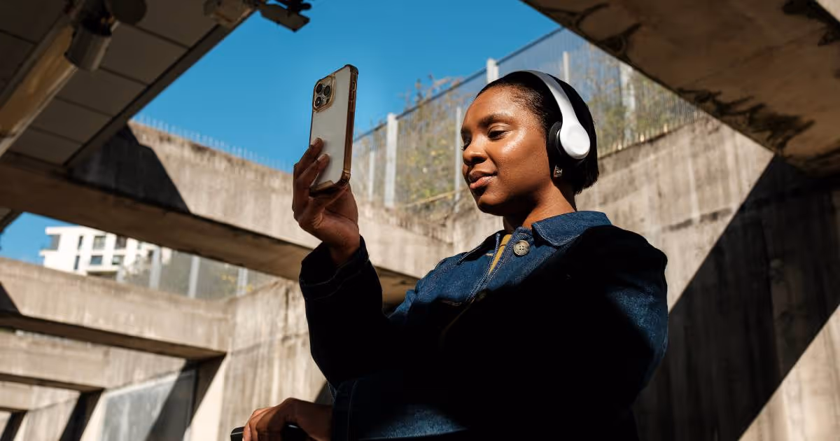 Woman recording video on her phone while outside on the street.