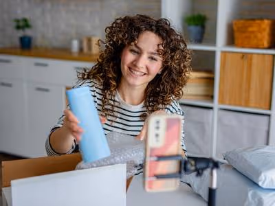 Woman reviewing product while recording on her phone.