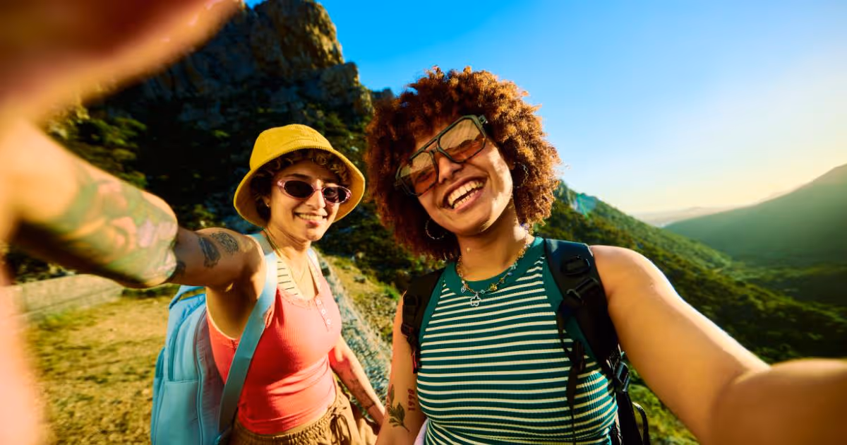 Two female friends taking a selfie while on a hike.