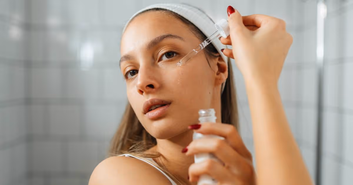 Close up of a girl in the mirror applying her skincare.