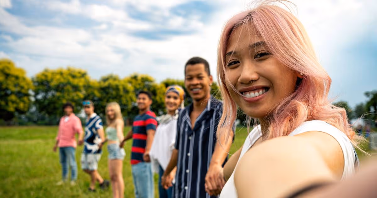 Group of friends holding hands at park.