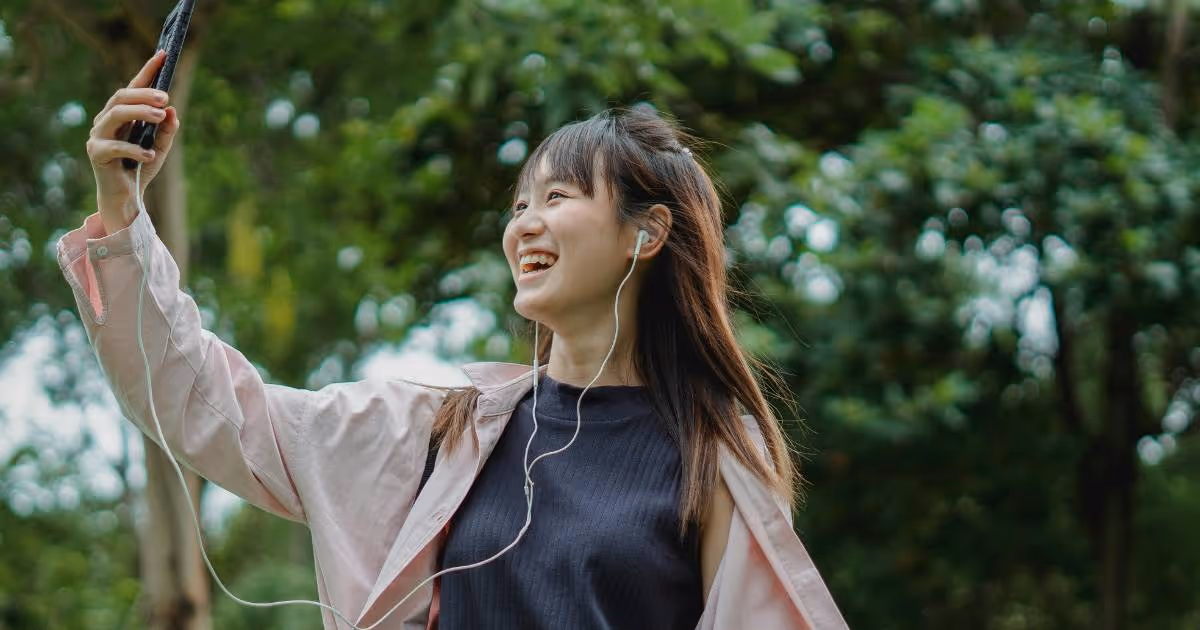 Woman using phone while walking in park.