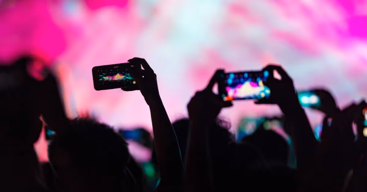 People recording concert on their smartphones, view from the crowd.