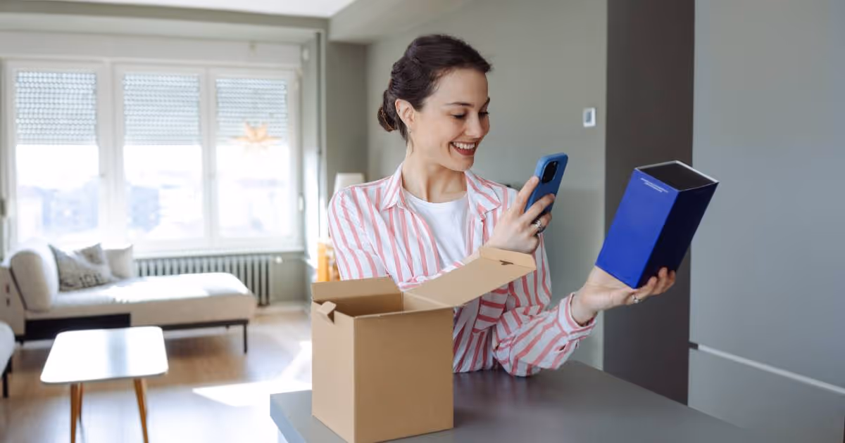 Woman taking video of a product opening, at home in her living room.