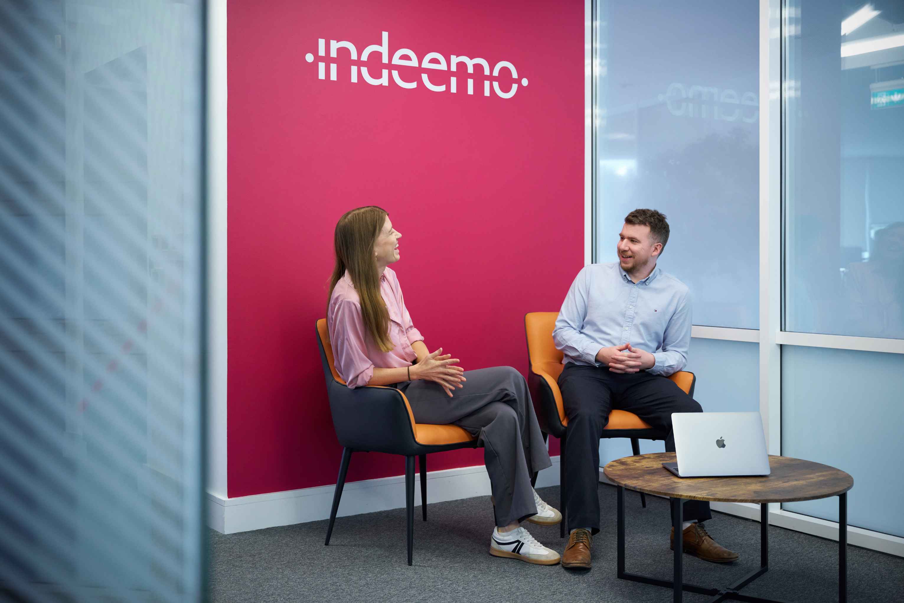 Indeemo team talking to each other in reception area of the office.