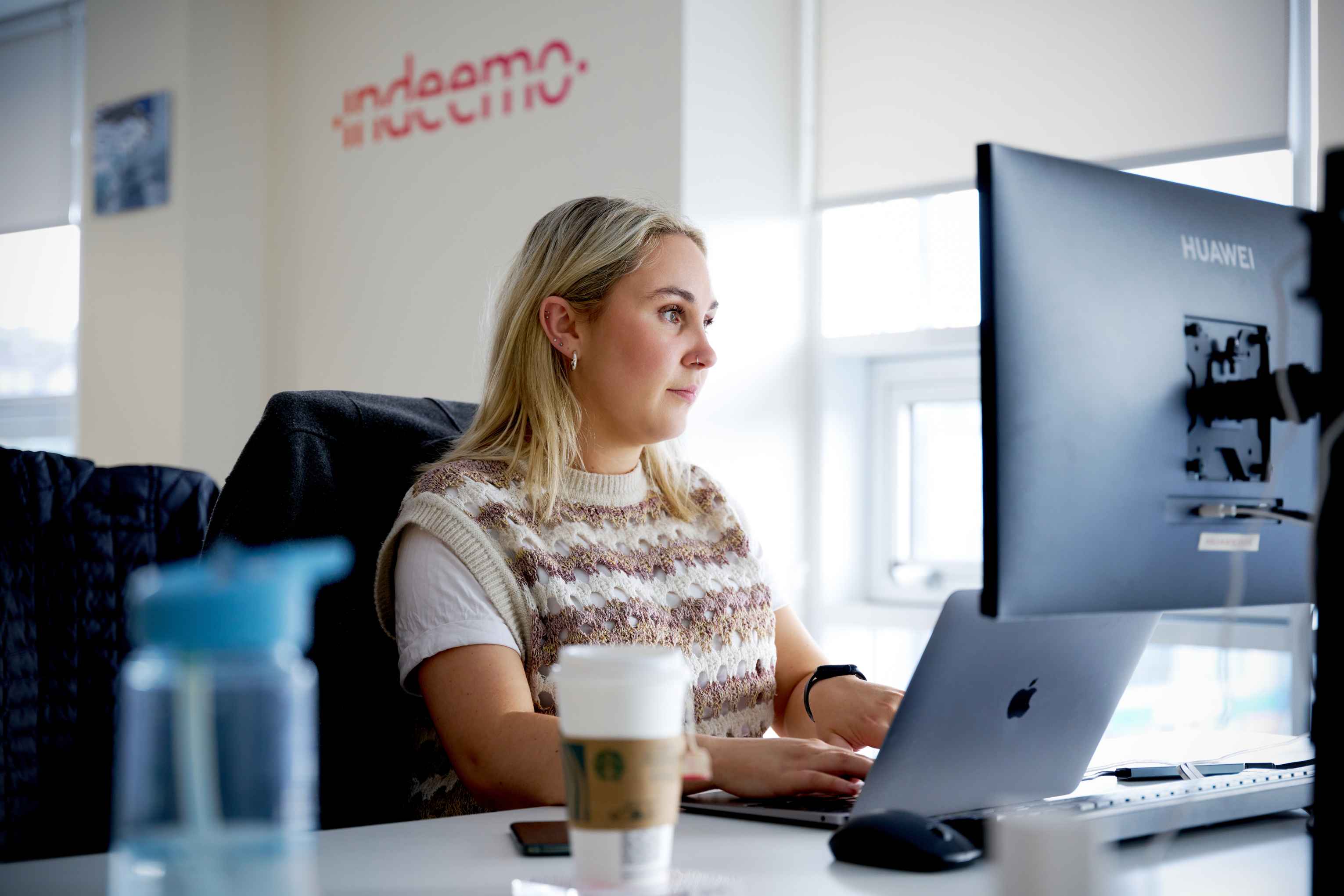 Indeemo employee typing at her desk.