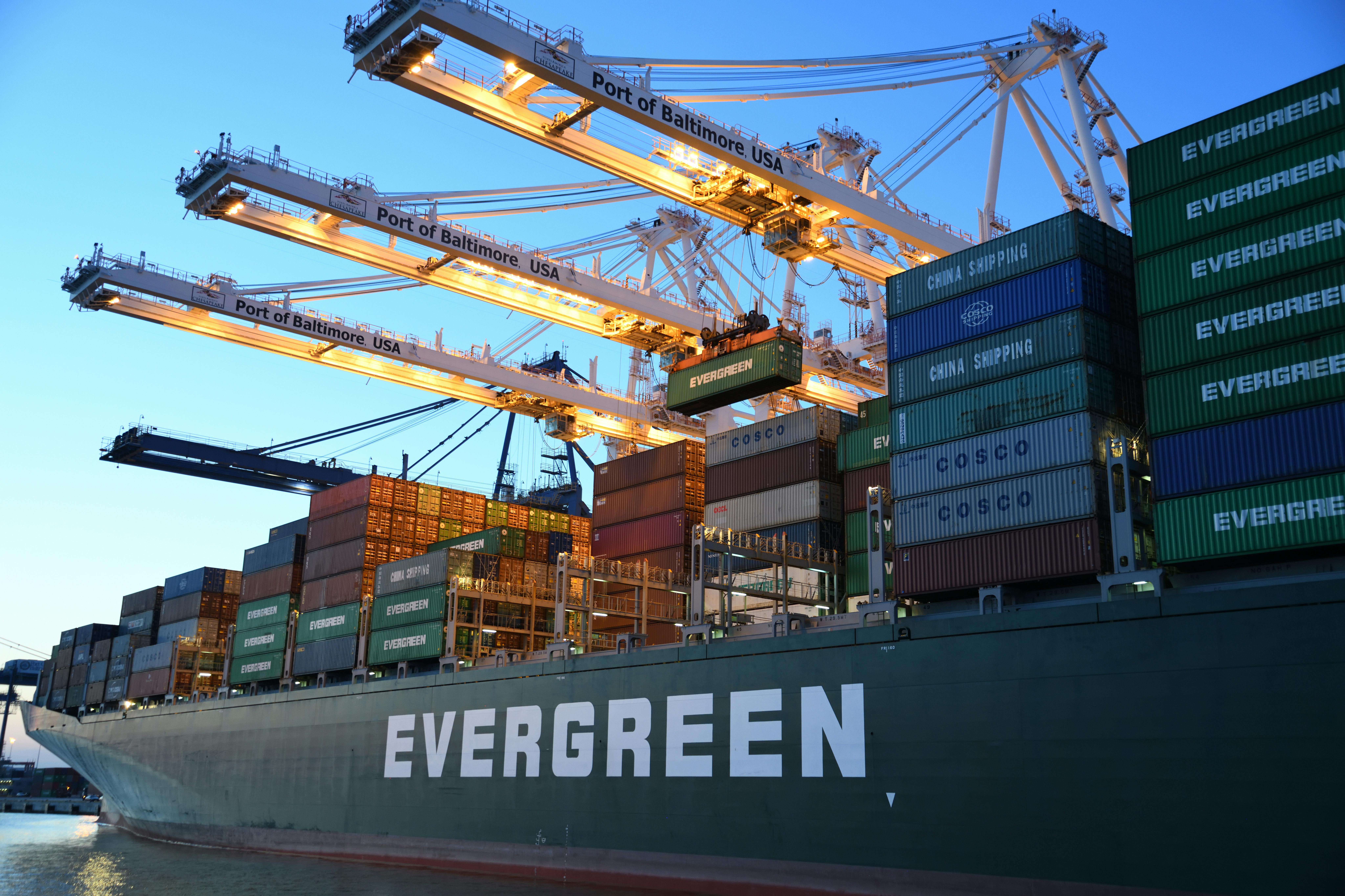 An Evergreen container ship being worked by cranes at the Port of Baltimore at dusk
