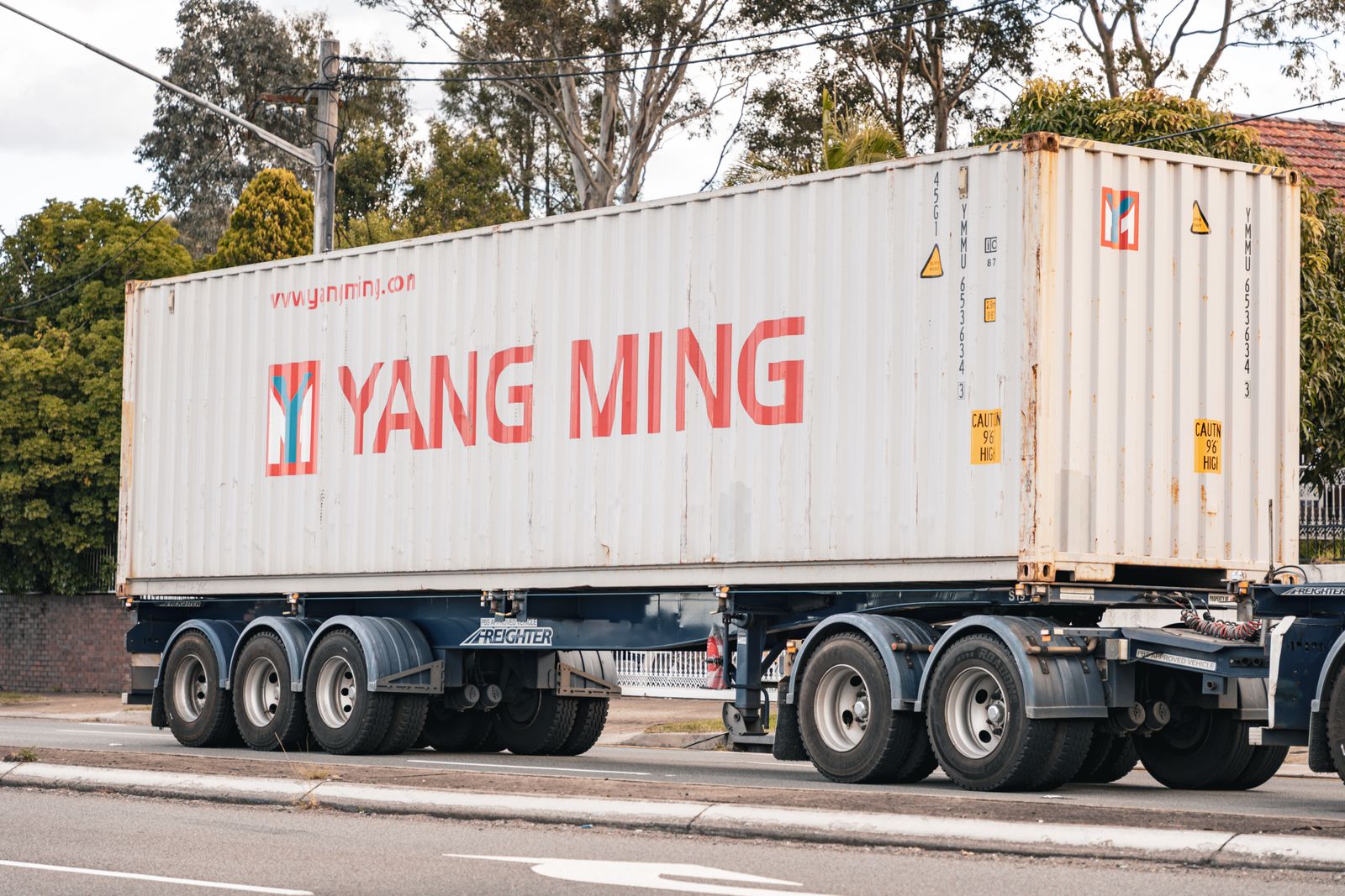 A shipping container on a road going chassis trailer parked at the kerb