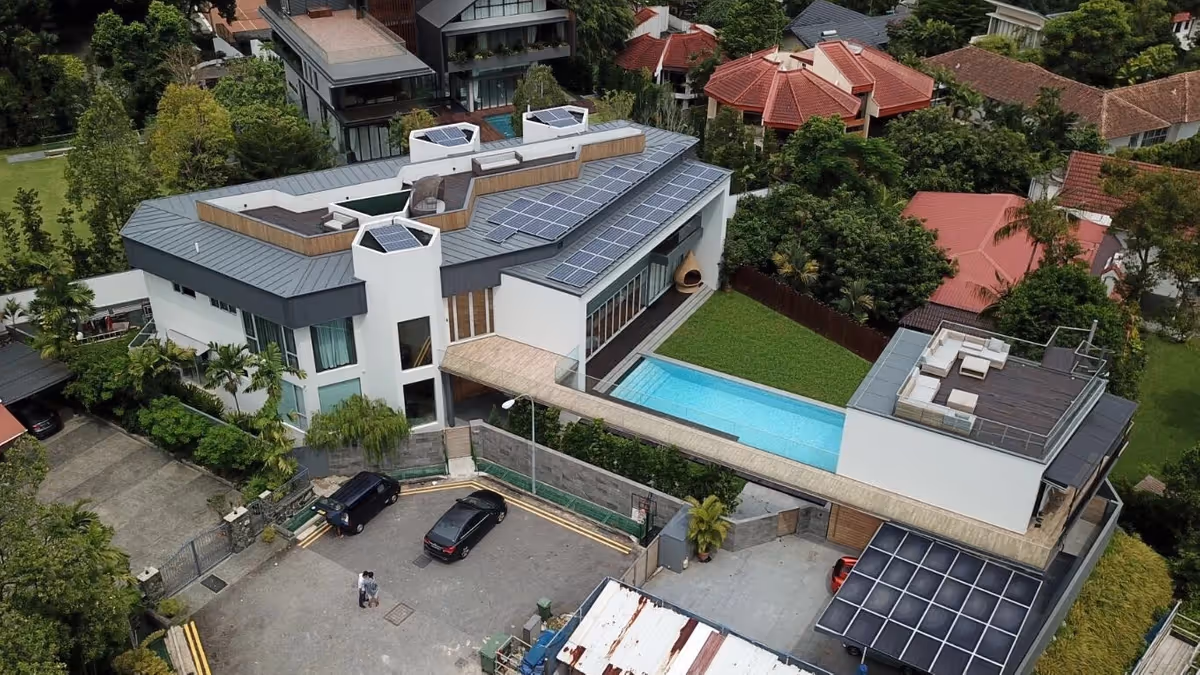 Aerial view of a 22.46 kWp solar panel installation on a modern Good Class Bungalow at Chee Hoon Avenue, Singapore, showing two panel arrays positioned around angular skylights on a metal roof, installed by Rezeca Renewables in 2018
