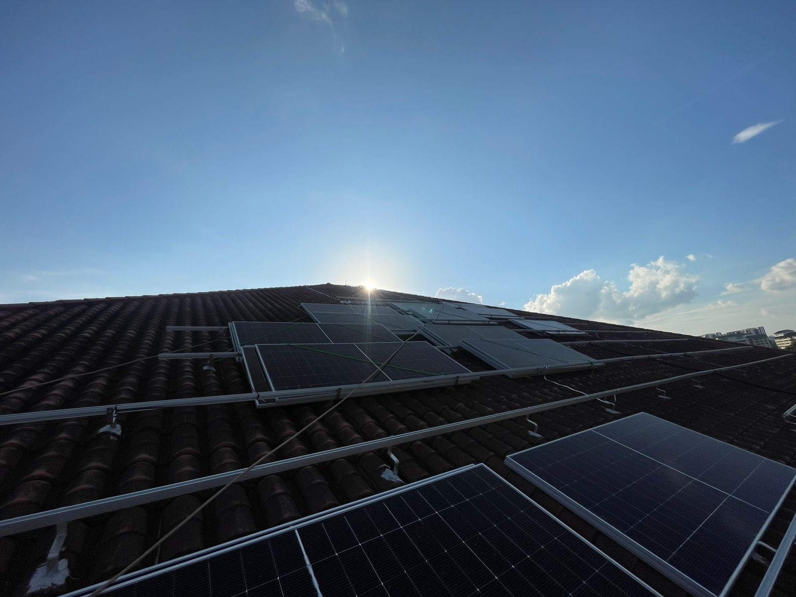 Rezeca Renewables installers fitting solar panels on the tiled roof of a Singapore landed home during installation