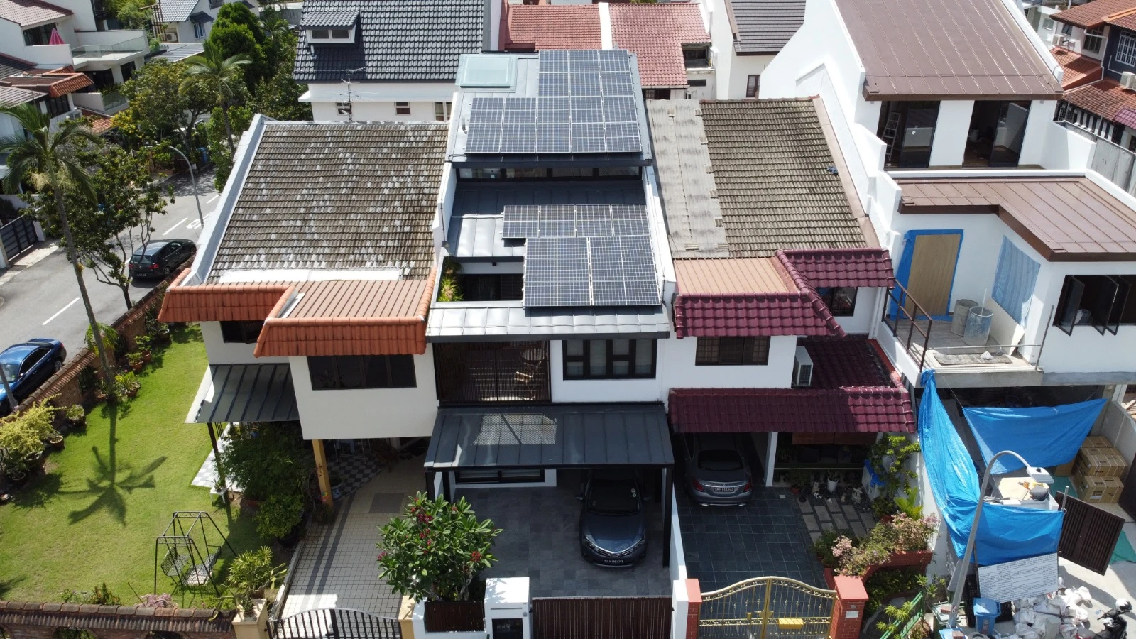 11.31 kWp solar system on a renovated inter-terrace home at Pemimpin Place, Singapore. Panels mounted on a flat metal roof extension above original tile sections. Commissioned 2024.