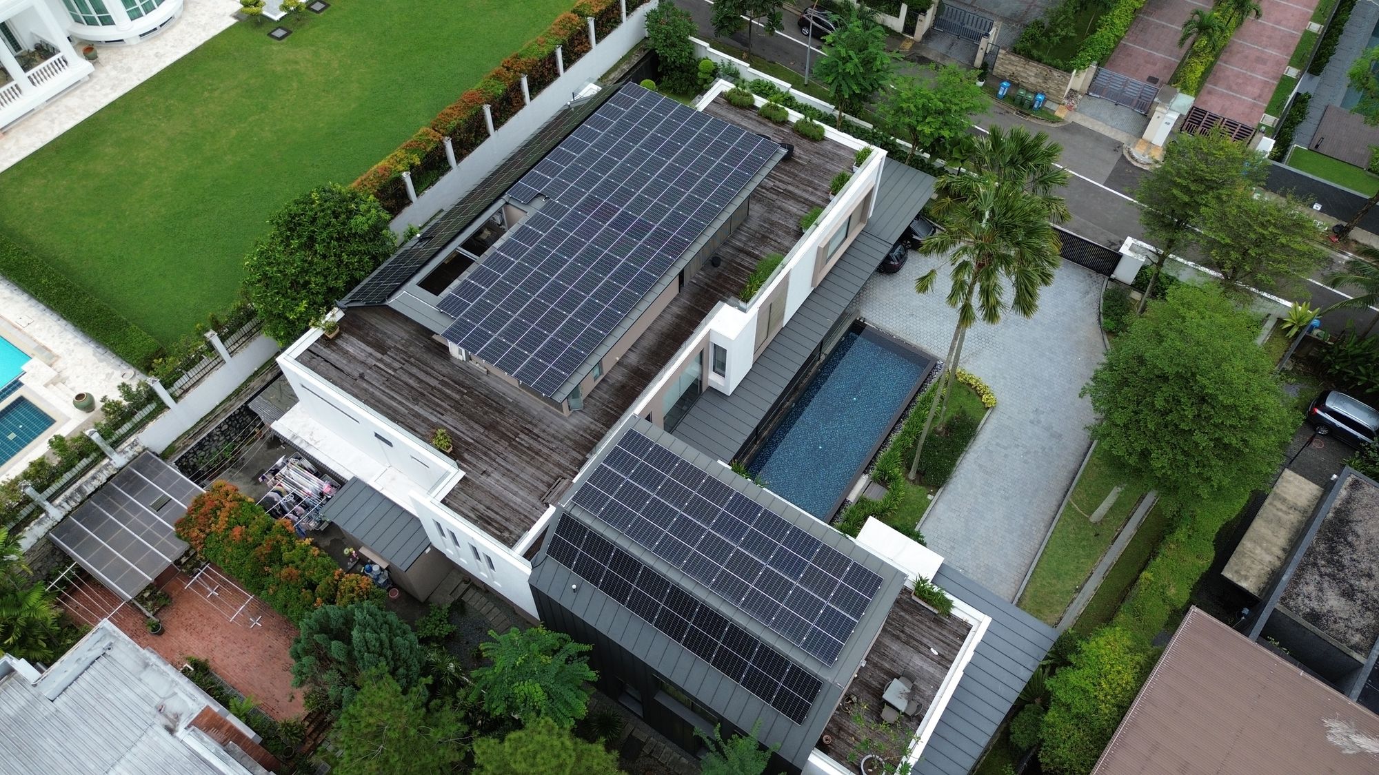 Aerial view of solar panel installation on a Singapore landed home, with panels mounted across two flat and pitched roof sections of a modern detached house
