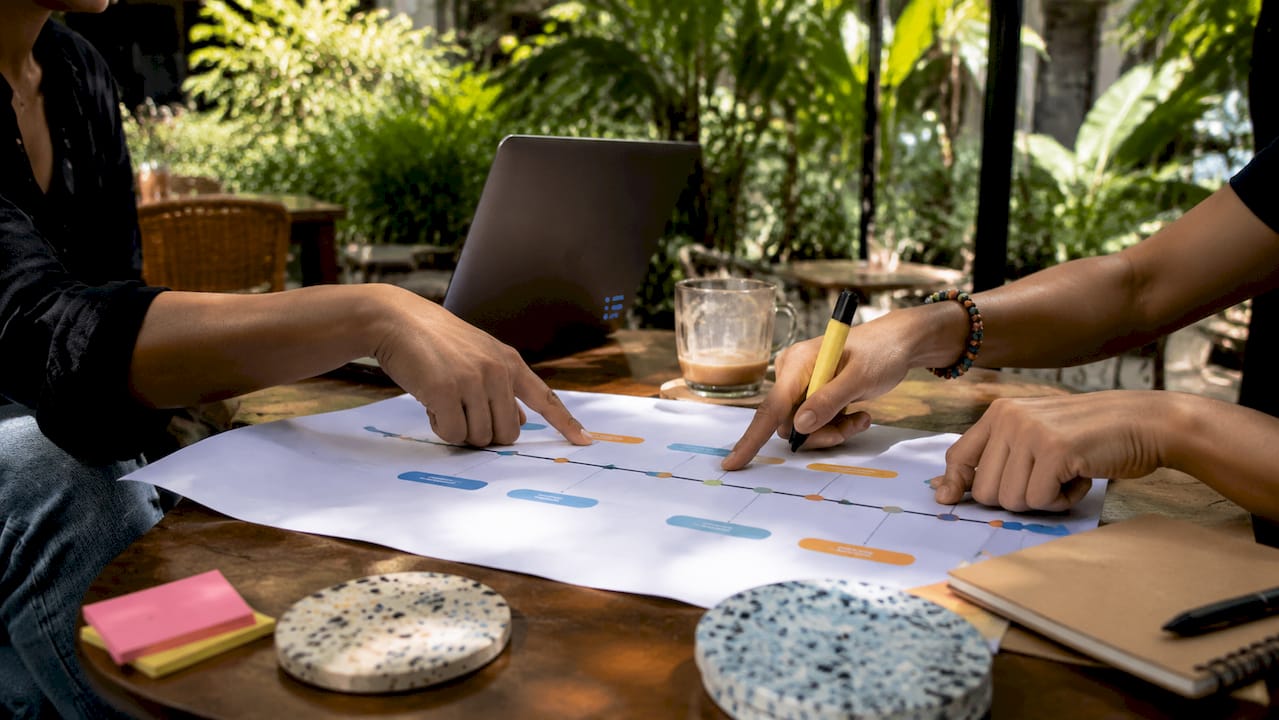 Hands pointing at project milestone timeline