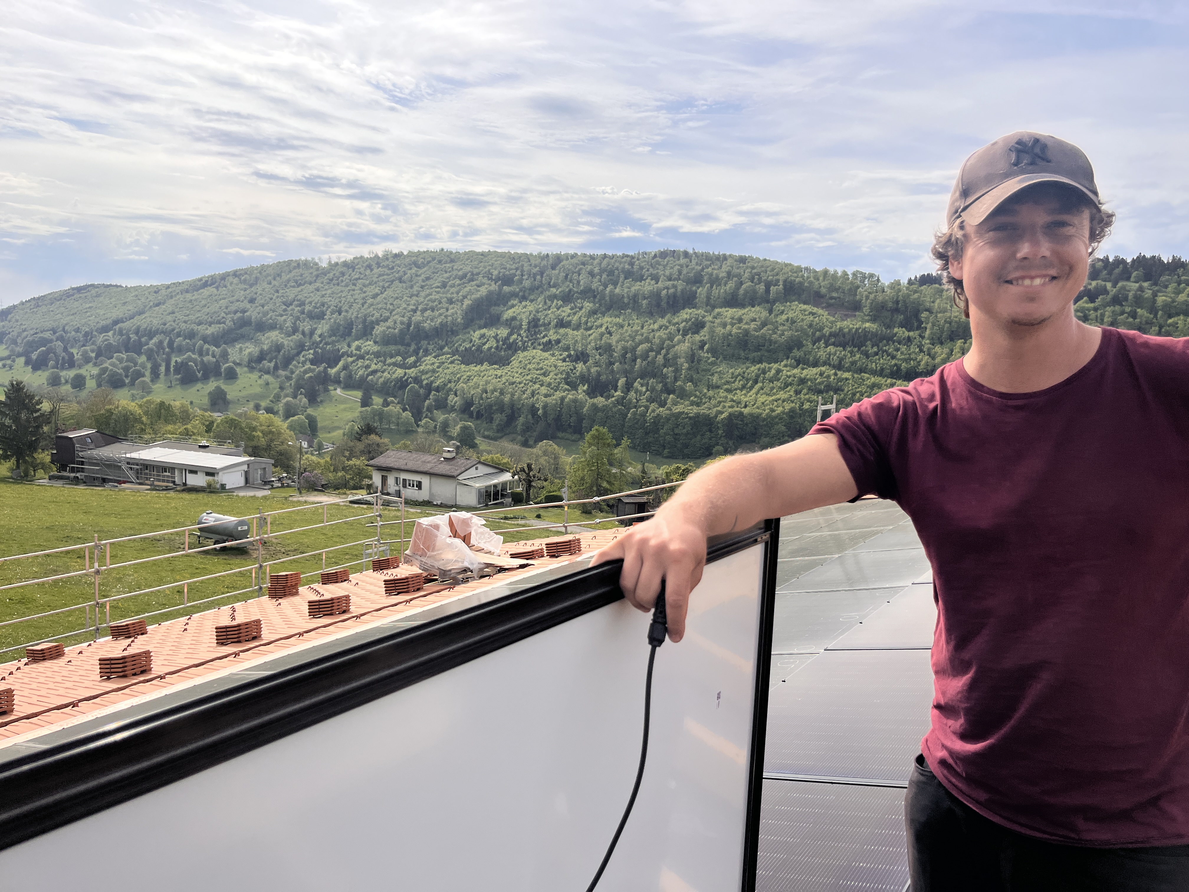 Dimi vom Solarmaa-Team, stolz auf dem Dach der Solrif-Indach-Anlage in Plagne im Berner Jura