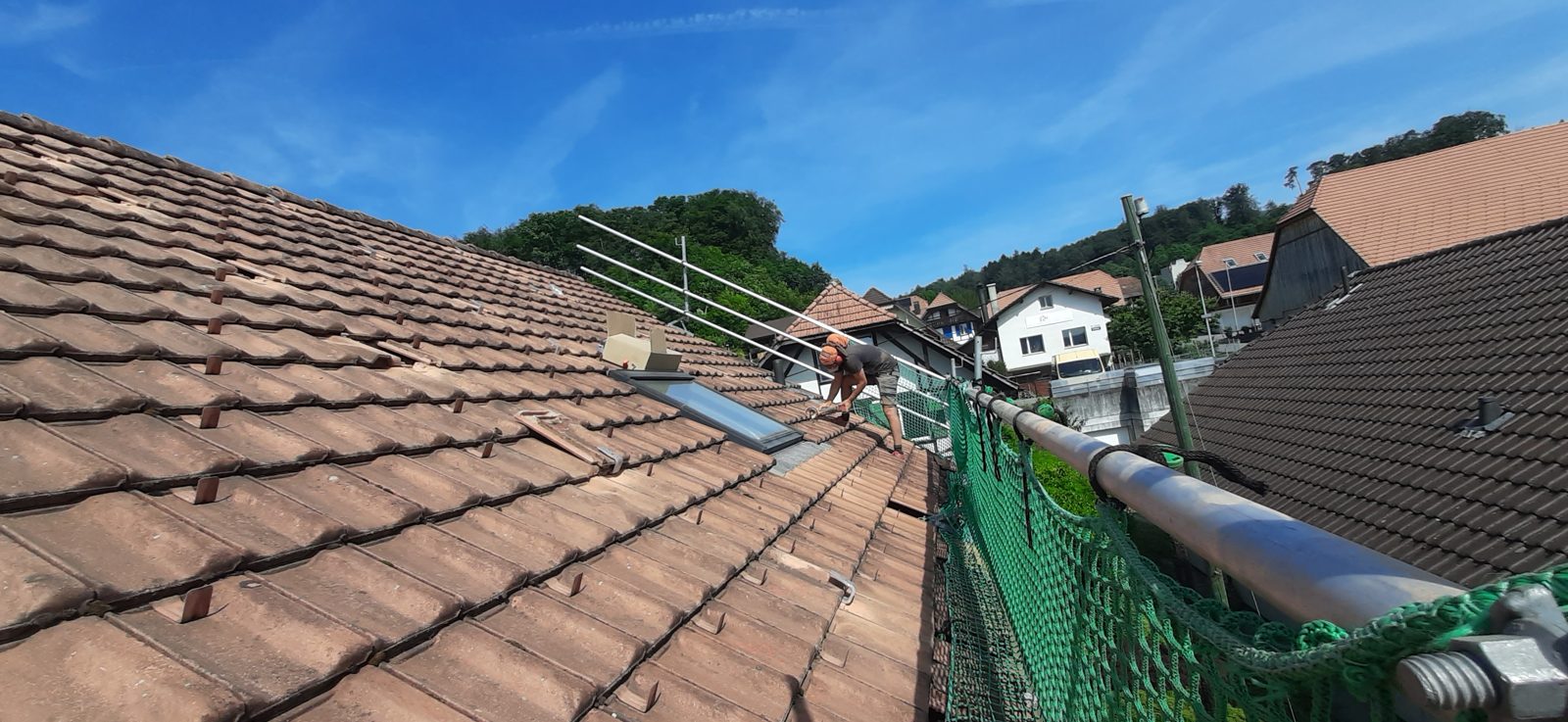 Monteur bei der Arbeit auf dem Ziegeldach in Safnern