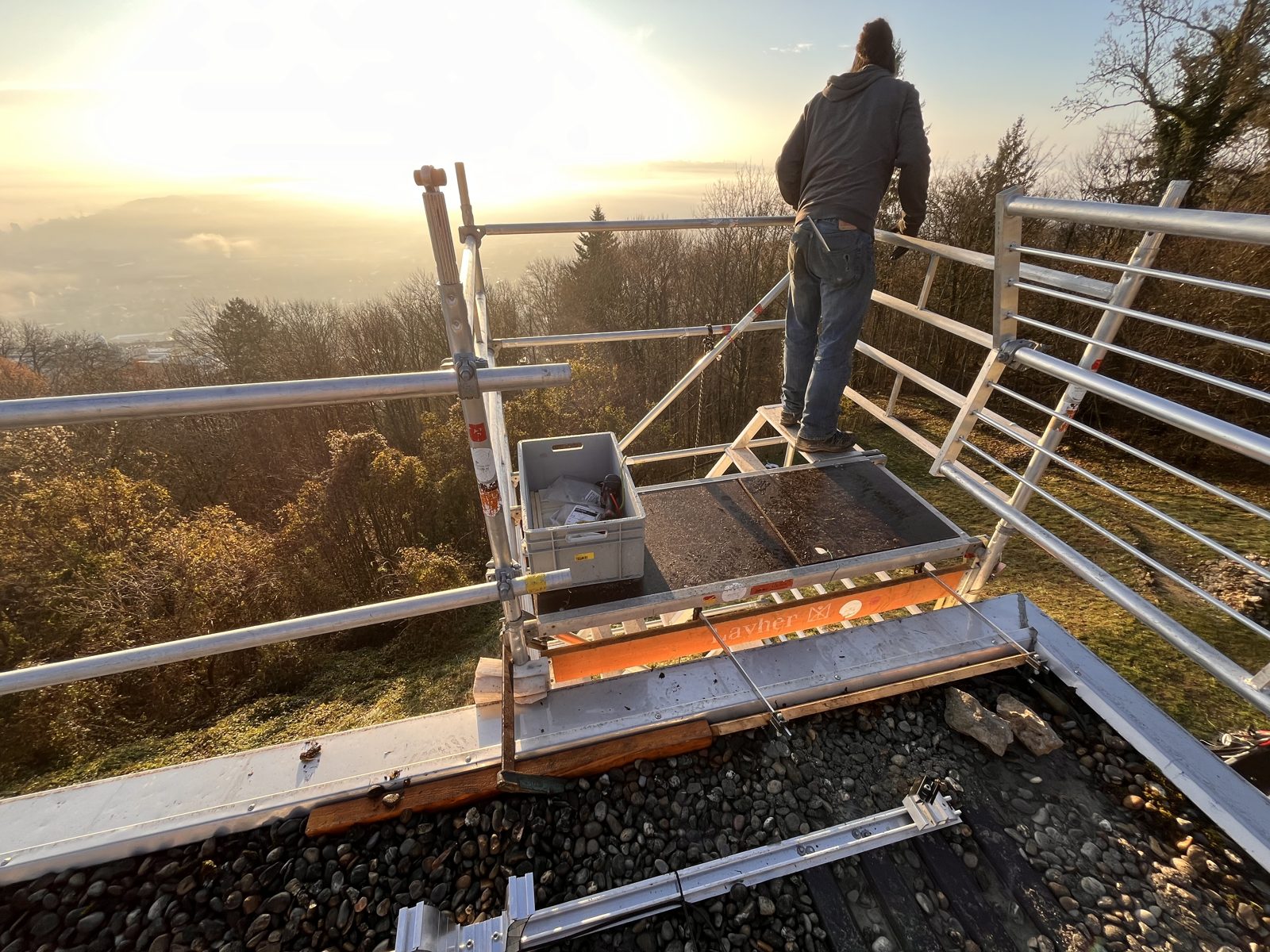 Solarmaa-Monteur auf dem Gerüst in Évilard bei Morgenlicht