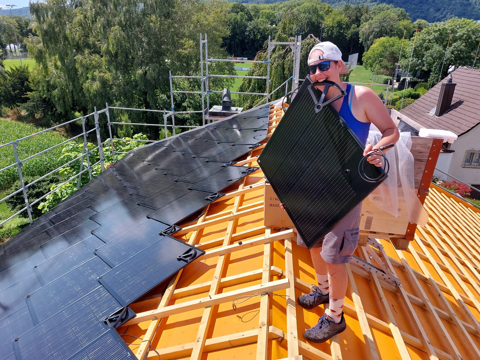 Solarmaa-Monteurin verlegt einen Sunstyle-Solarziegel auf dem Dach in Nidau