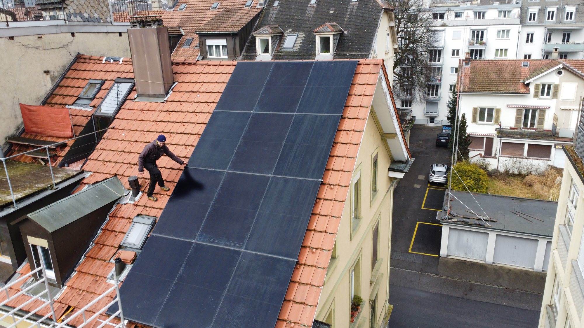 Monteur auf dem Ziegeldach während der Montage der Aiko-Module