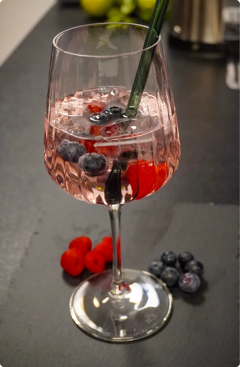 Fruchtiger Cocktail mit Beeren im Weinglas für Hochzeiten und private Feiern
